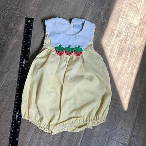 Baby girl yellow bubble romper w/ white scalloped collar w/ strawberries.